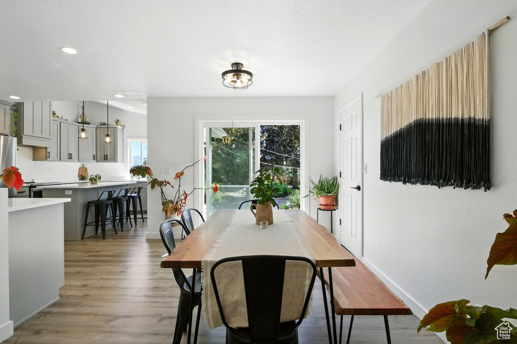 Dining area with light wood-style floors and recessed lighting