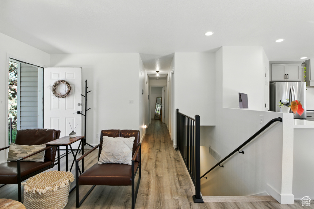 Living room with light wood finished floors and recessed lighting