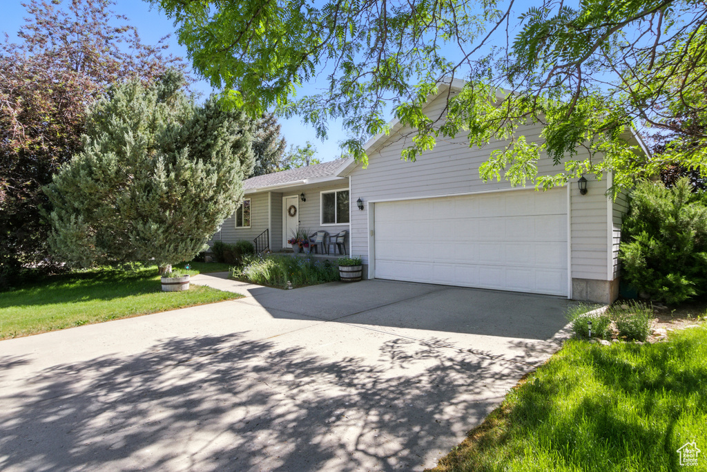 View of front of home featuring concrete driveway and an attached garage