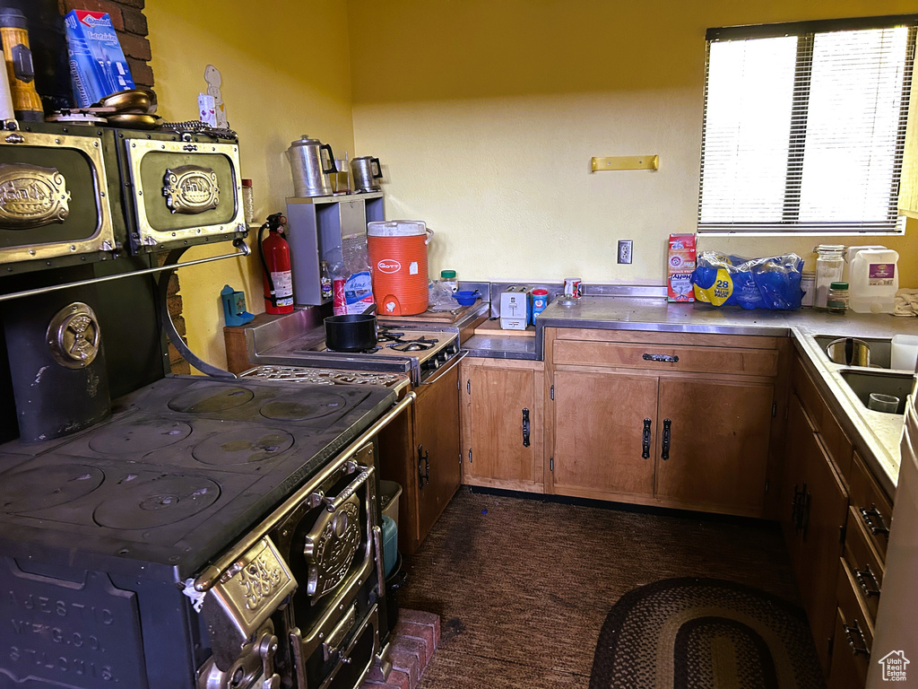 Kitchen featuring brown cabinetry and dark colored carpet