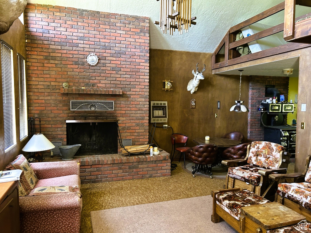 Living area featuring carpet floors, heating unit, and a brick fireplace