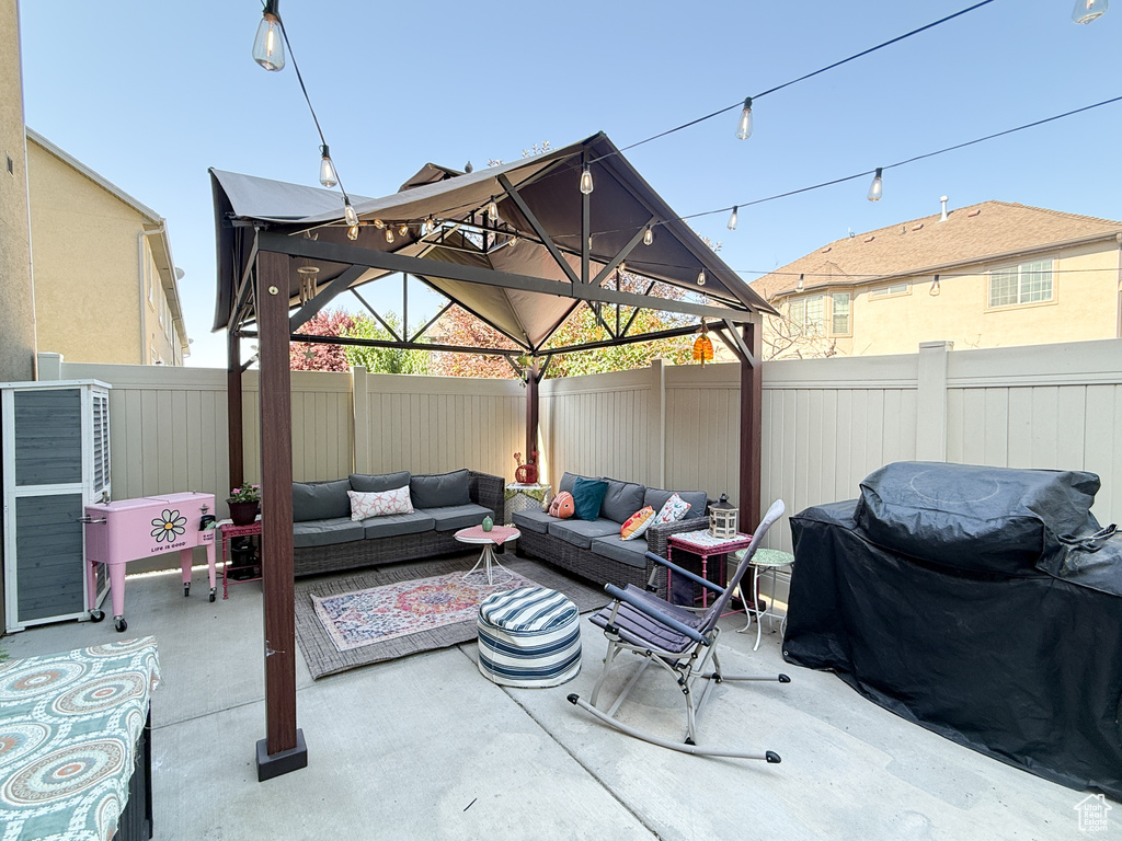 Fenced backyard featuring a gazebo, an outdoor living space, a patio area, and a grill