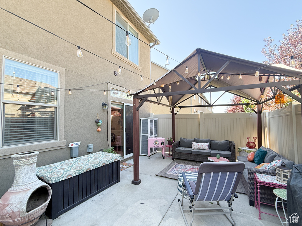Fenced backyard featuring a gazebo, an outdoor living space, and a patio area