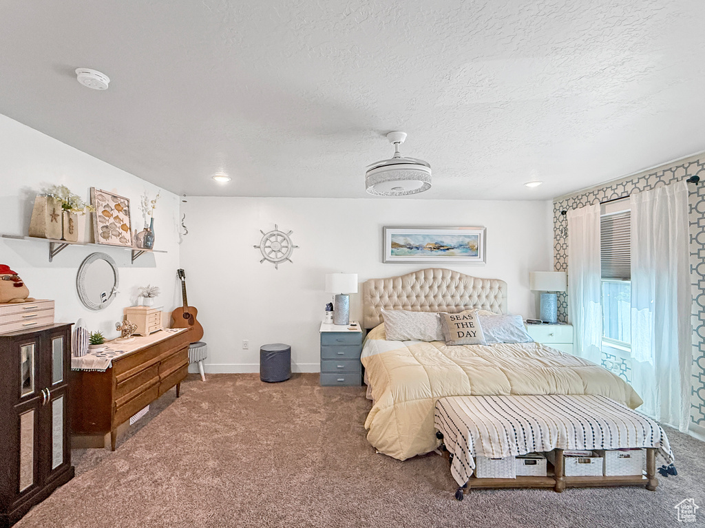 Carpeted bedroom with a textured ceiling and baseboards