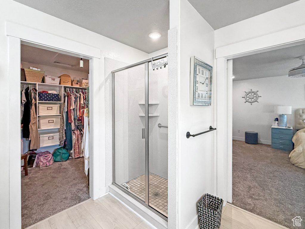 Full bathroom with a shower stall and a walk in closet