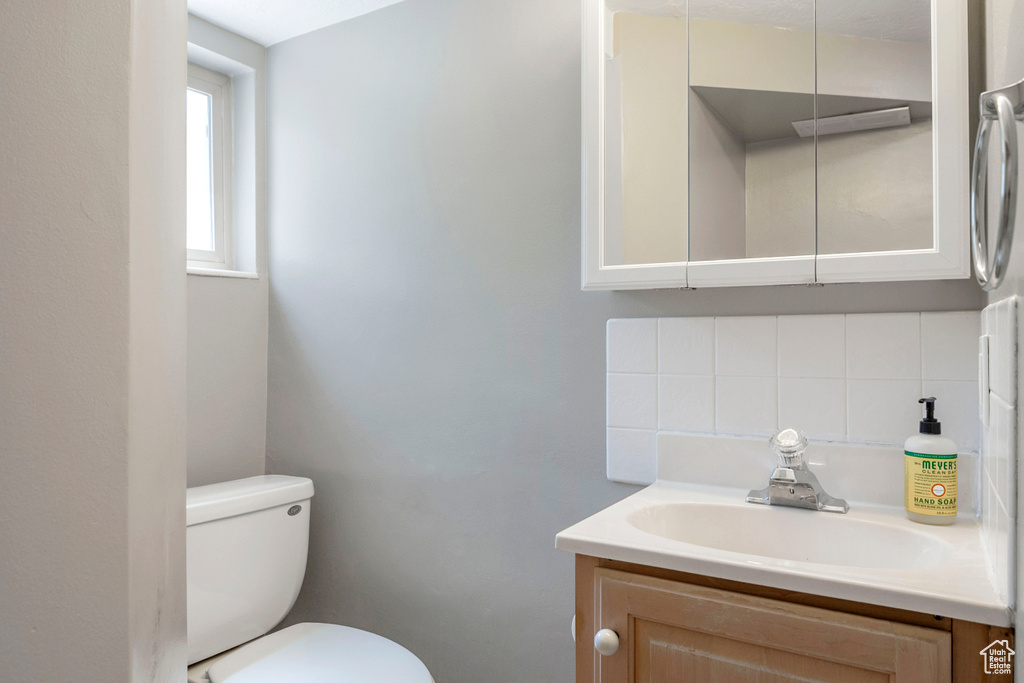 Half bathroom featuring tasteful backsplash and vanity