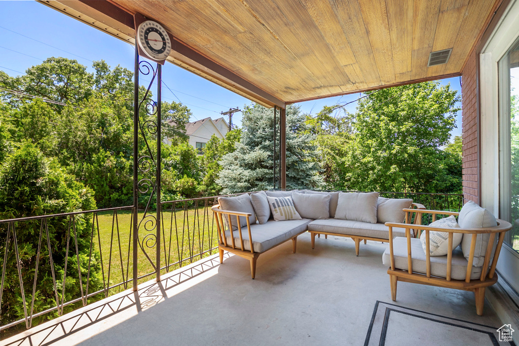 Patio / terrace with outdoor lounge area, view of scattered trees, and a lawn