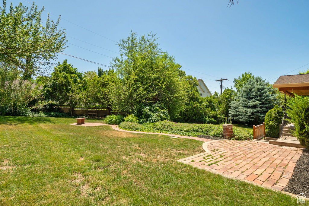 View of green lawn featuring a patio