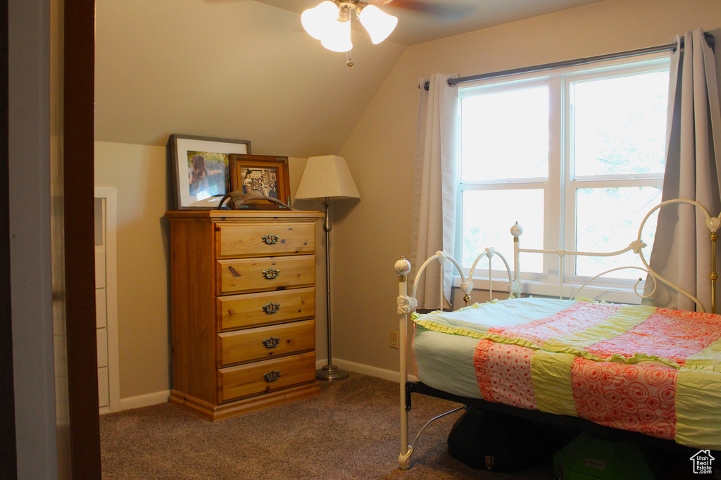 Carpeted bedroom with vaulted ceiling and a ceiling fan