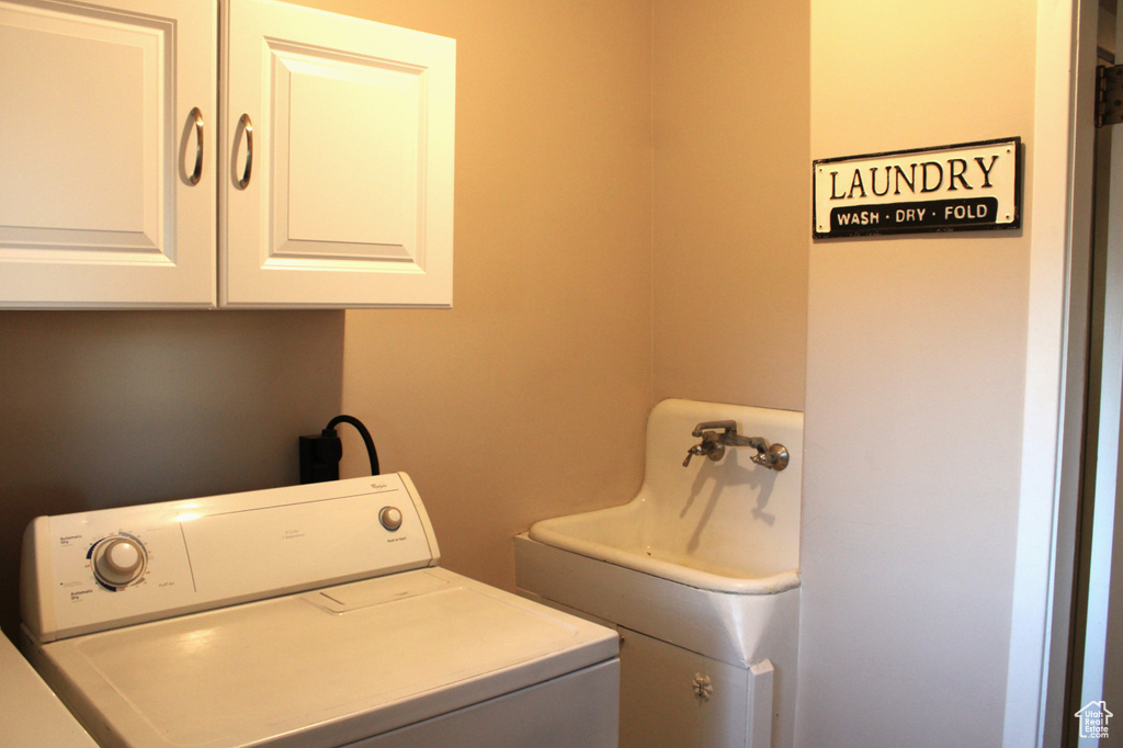 Washroom featuring cabinet space and washing machine and dryer