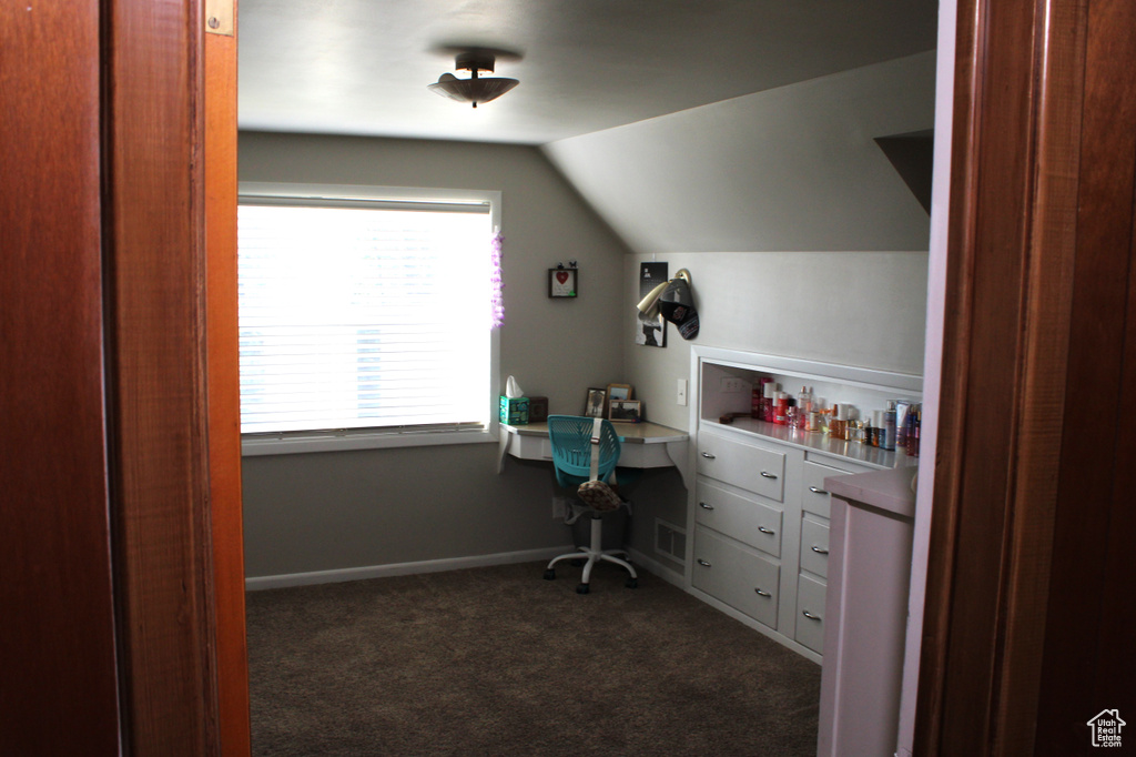 Office space featuring lofted ceiling and dark carpet