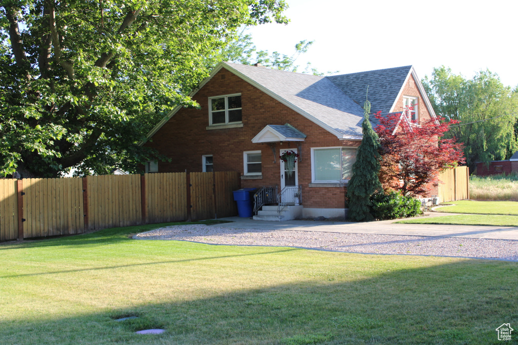 View of front of home featuring roof with shingles and brick siding