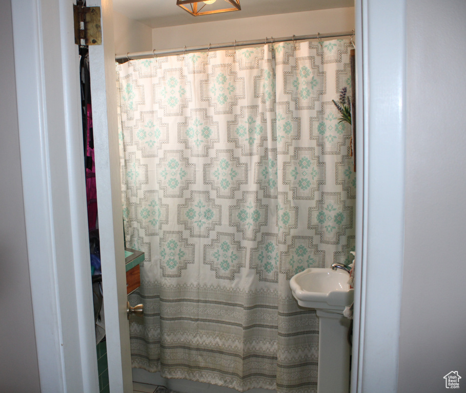 Full bathroom featuring curtained shower and a sink