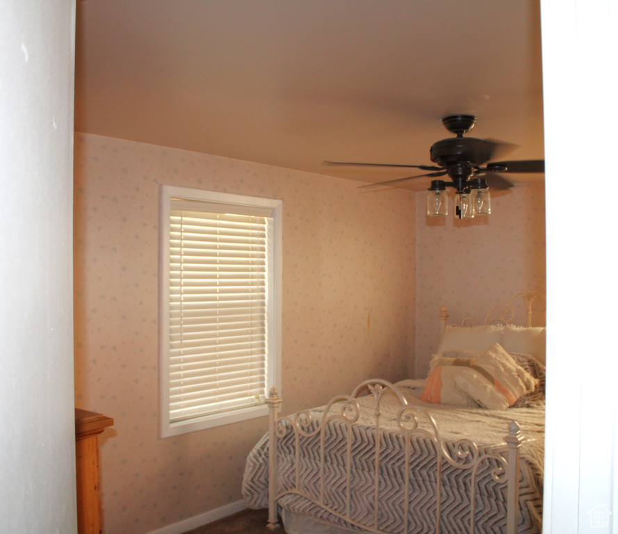 Bedroom featuring wallpapered walls and ceiling fan