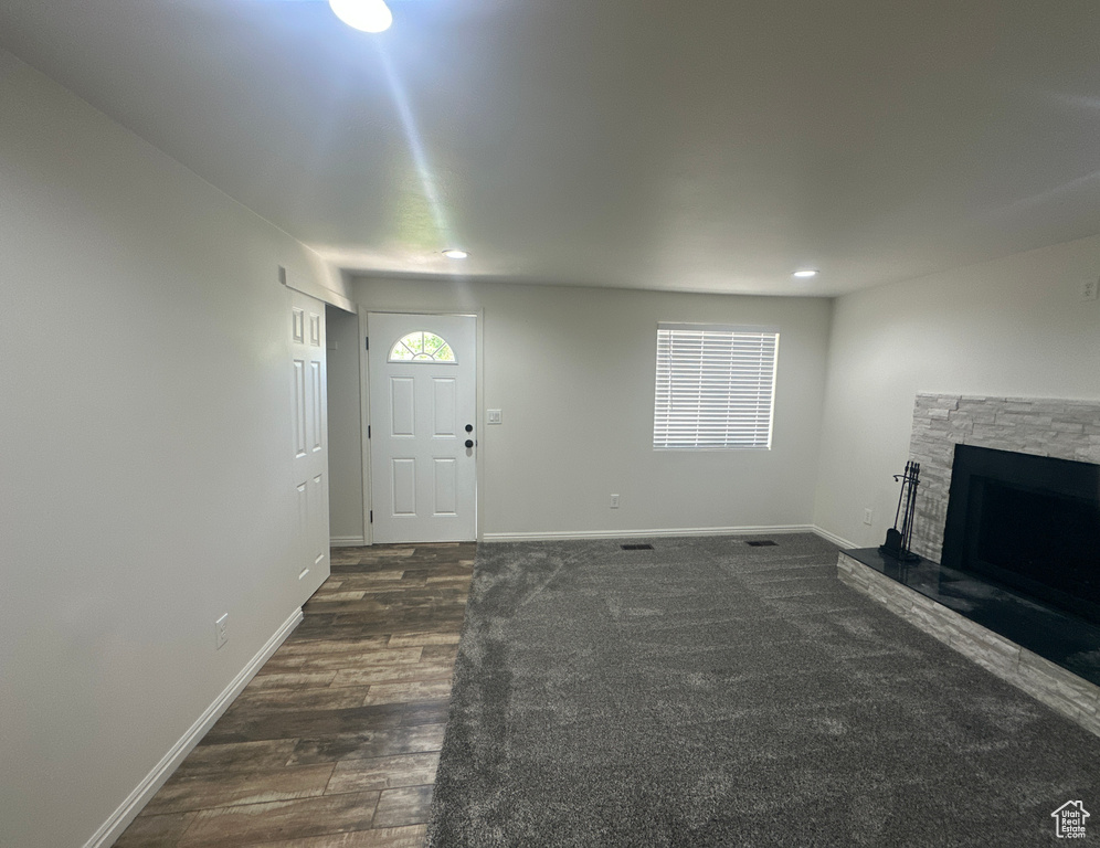 Unfurnished living room featuring a fireplace, dark wood finished floors, plenty of natural light, and recessed lighting
