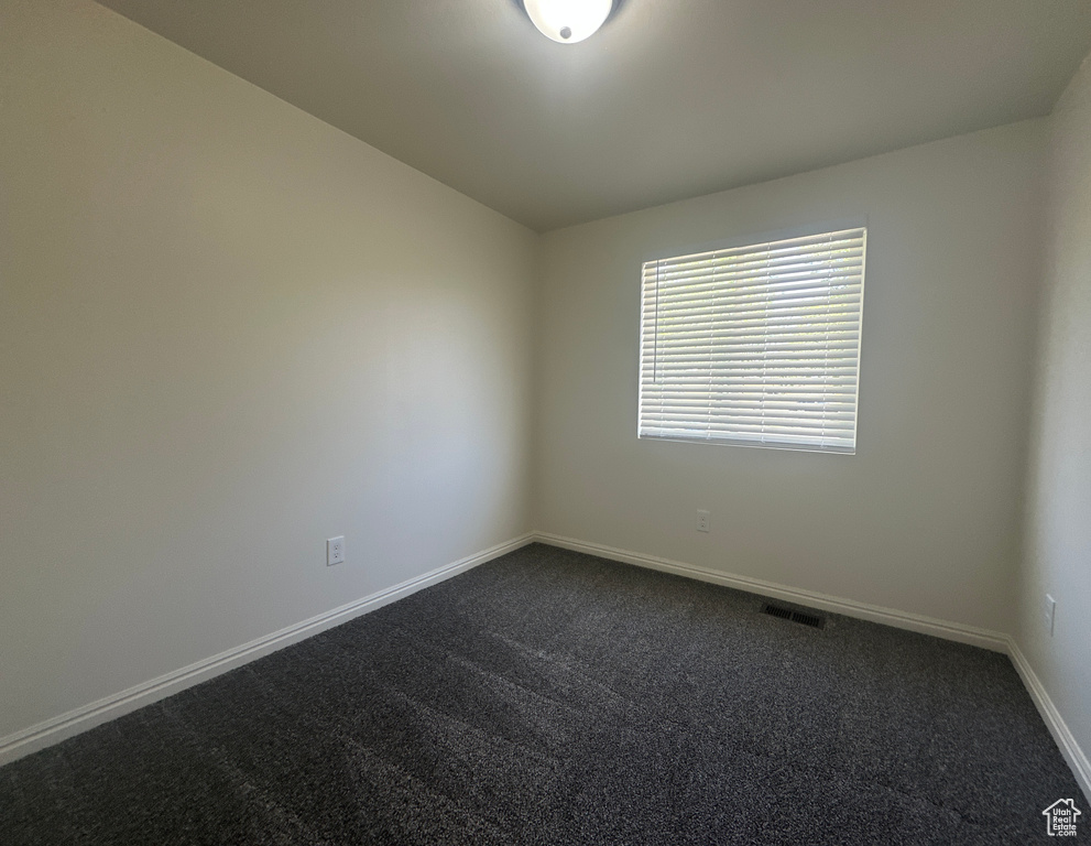 Empty room featuring dark carpet