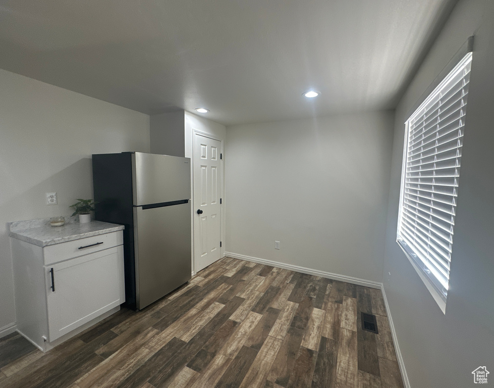 Kitchen with freestanding refrigerator, dark wood-type flooring, recessed lighting, light countertops, and white cabinetry