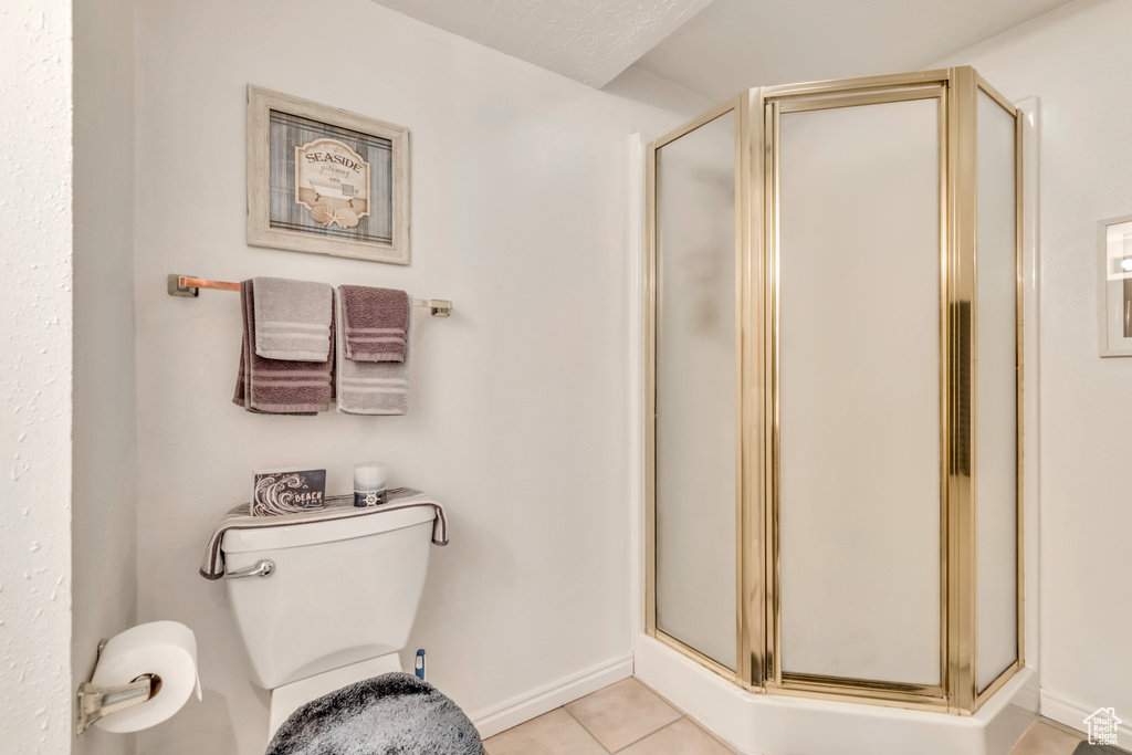 Full bath featuring a shower stall and tile patterned flooring