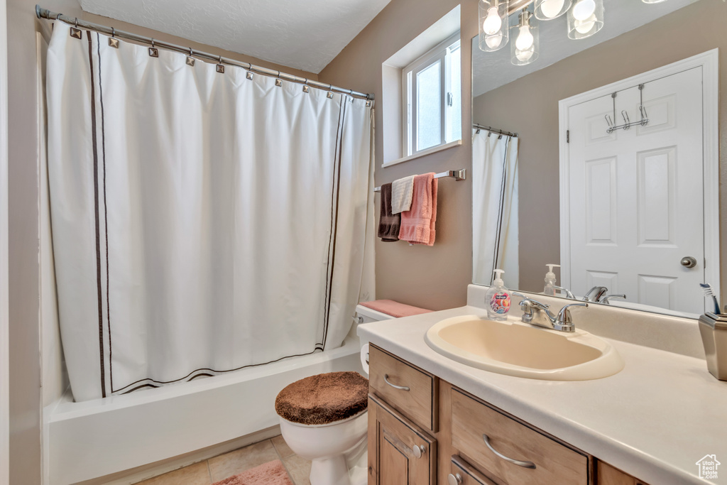 Bathroom with vanity, shower / tub combo with curtain, and tile patterned flooring