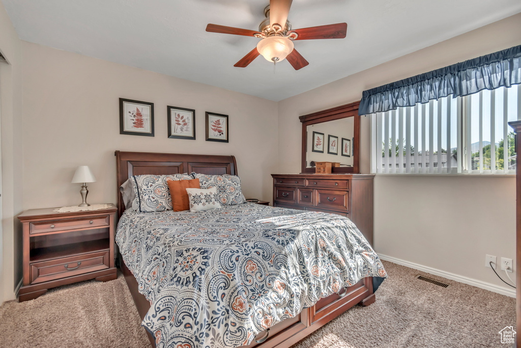 Carpeted bedroom featuring baseboards and ceiling fan