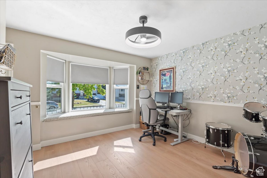 Office area featuring wallpapered walls and wood finished floors