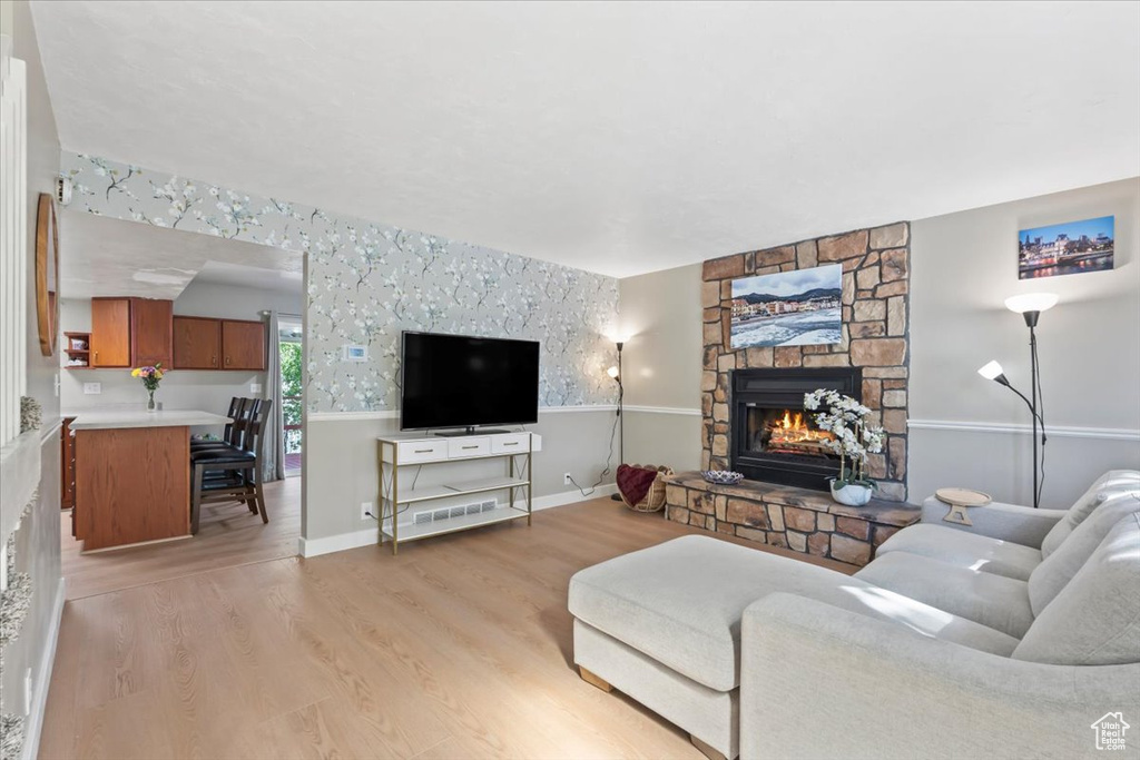 Living area featuring a stone fireplace and light wood-type flooring