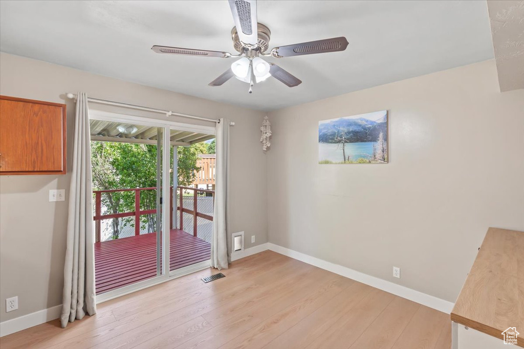 Empty room with light wood finished floors and a ceiling fan