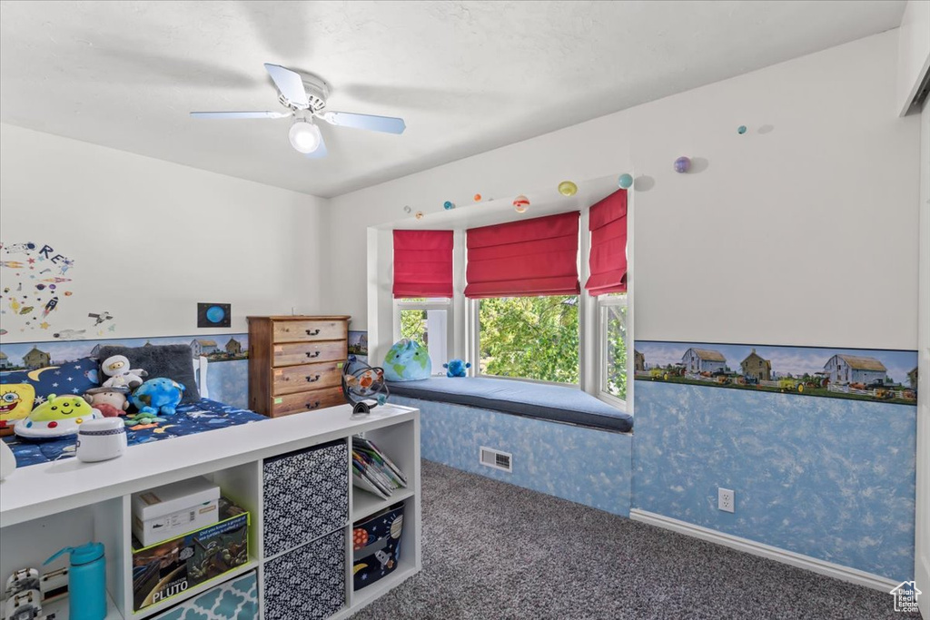 Carpeted bedroom featuring a ceiling fan