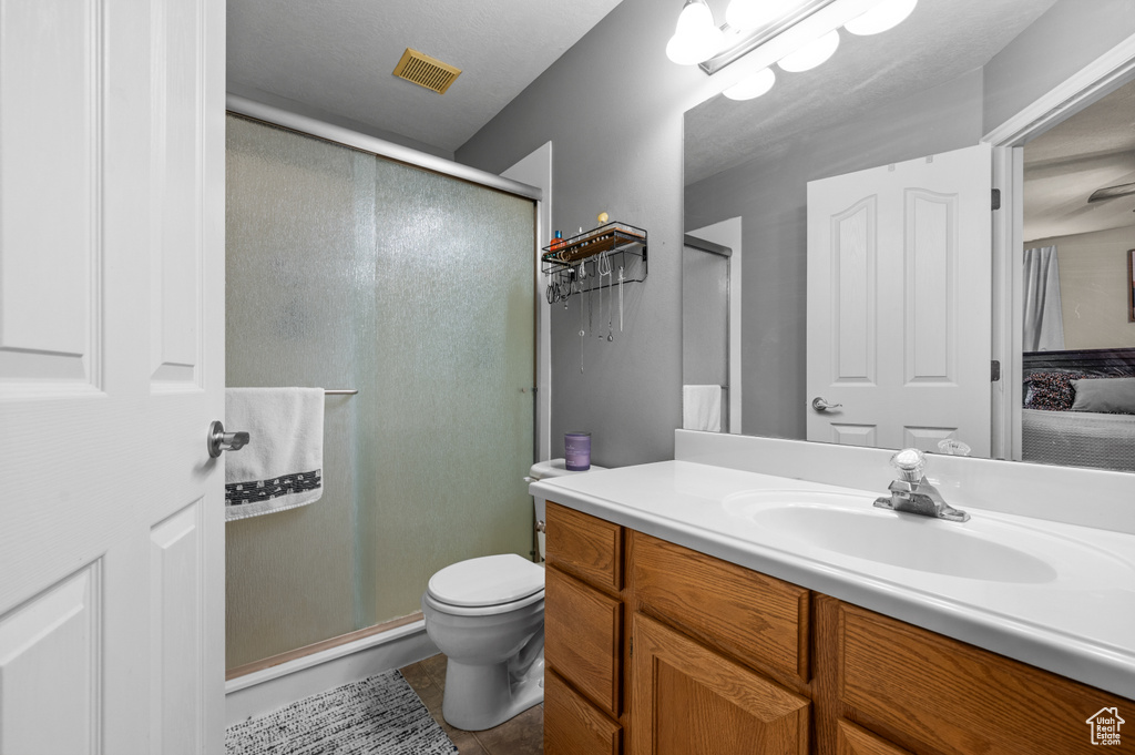 Ensuite bathroom featuring vanity, a shower stall, and tile patterned flooring