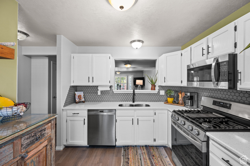 Kitchen with stainless steel appliances, light countertops, and white cabinets