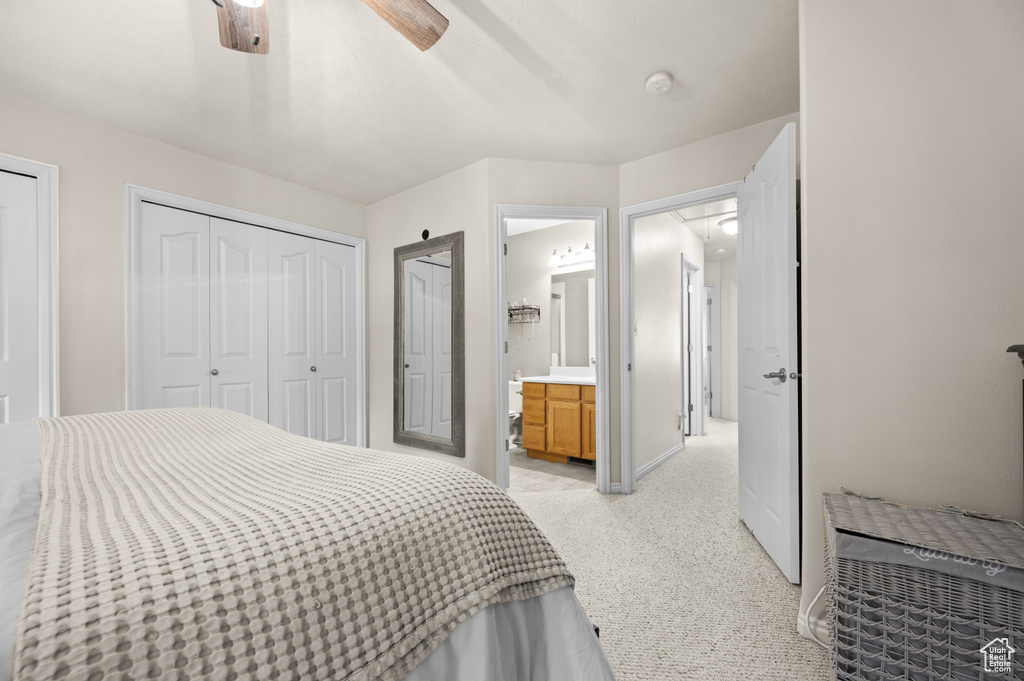 Bedroom with light colored carpet, ensuite bath, ceiling fan, and attic access