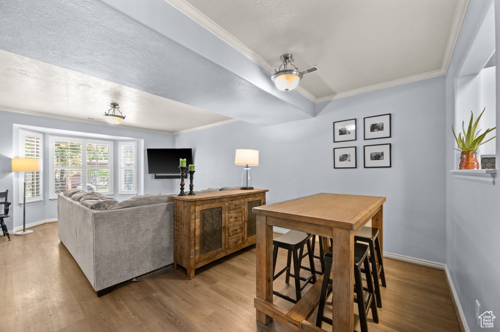 Living room featuring wood finished floors and crown molding