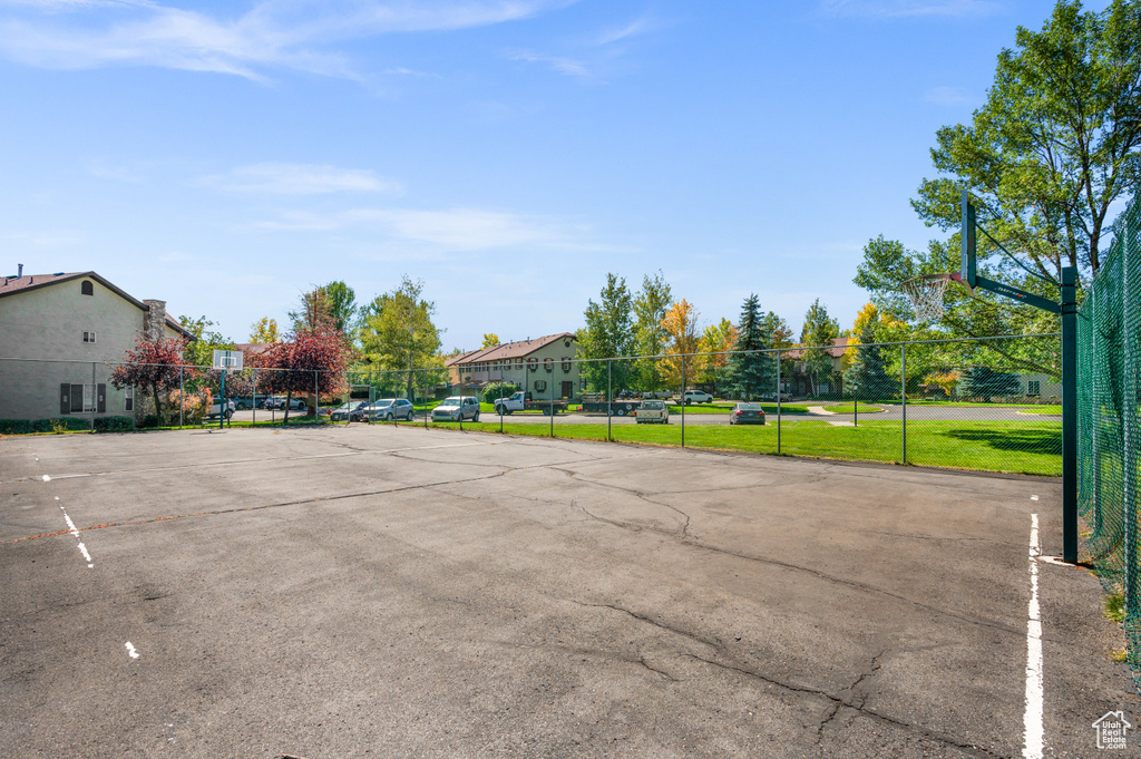 Uncovered parking lot featuring community basketball court and a residential view