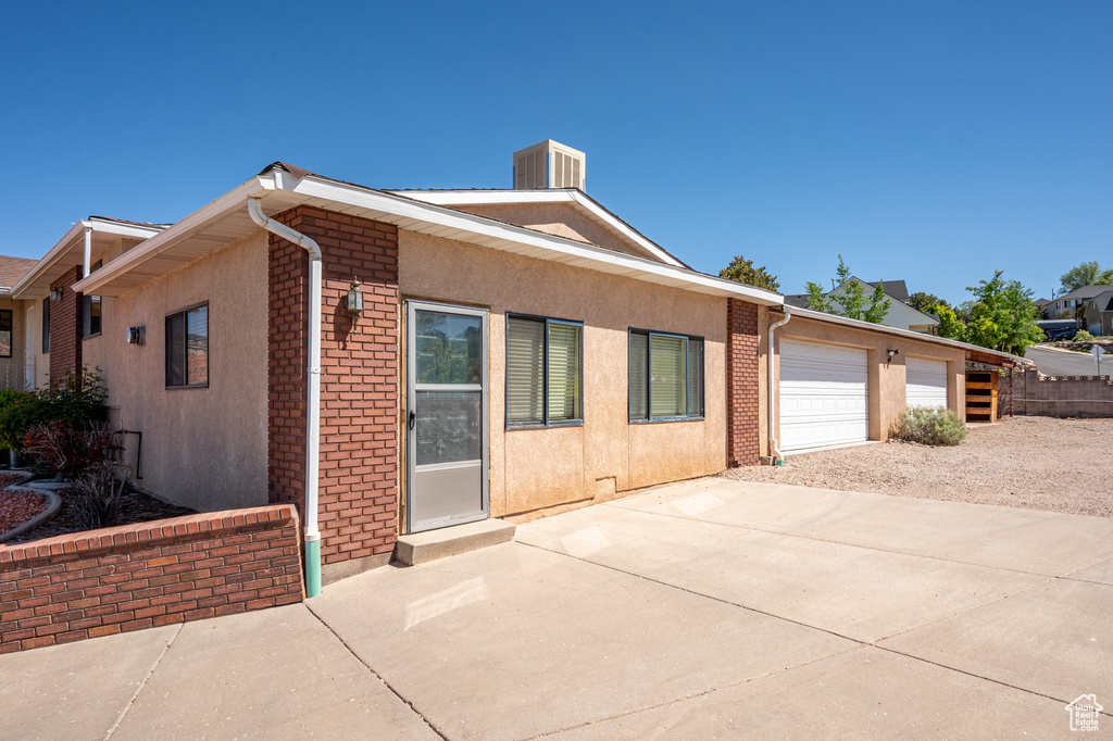 Ranch-style house featuring concrete driveway, brick siding, and stucco siding