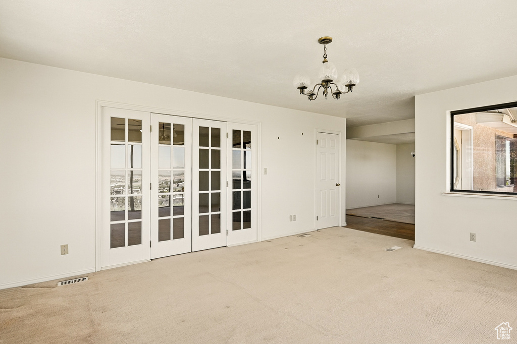 Spare room with a chandelier and carpet floors