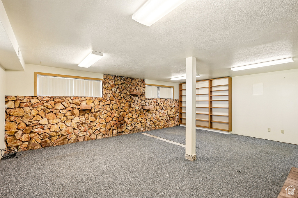Finished basement with a textured ceiling and carpet flooring