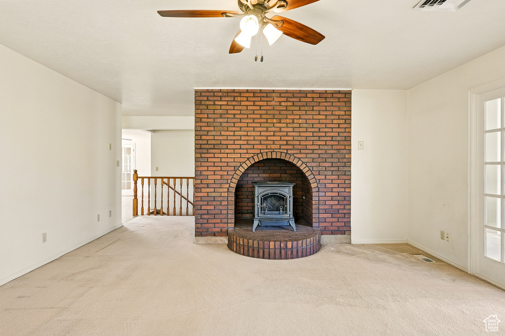 Unfurnished living room with carpet and a ceiling fan