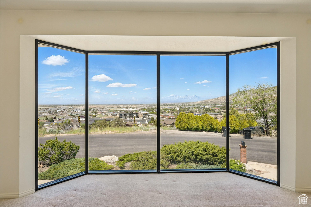 Carpeted empty room featuring healthy amount of natural light and a mountain view