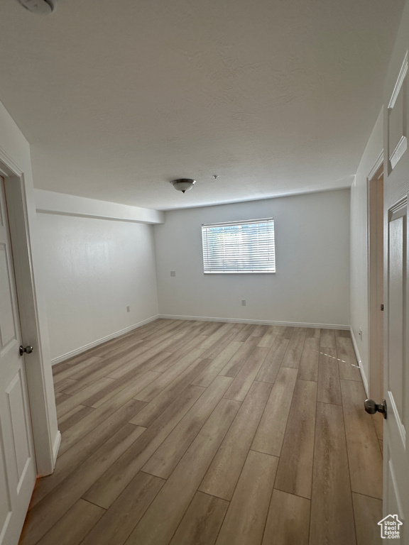 Unfurnished room with light wood-style floors and baseboards