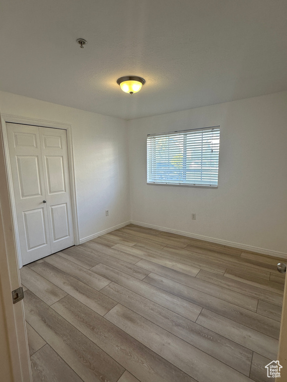 Unfurnished room with light wood-type flooring and a pendent fire sprinkler