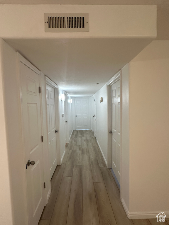 Hallway featuring wood finished floors and baseboards