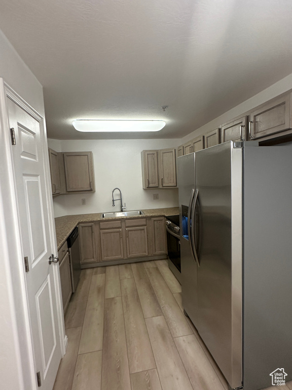 Kitchen with appliances with stainless steel finishes and light wood-style flooring