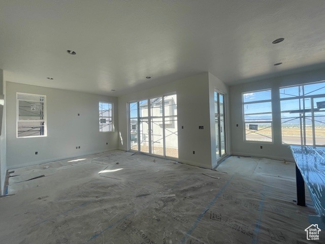 Unfurnished living room featuring baseboards