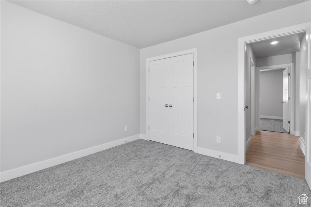 Unfurnished bedroom with carpet flooring and a closet