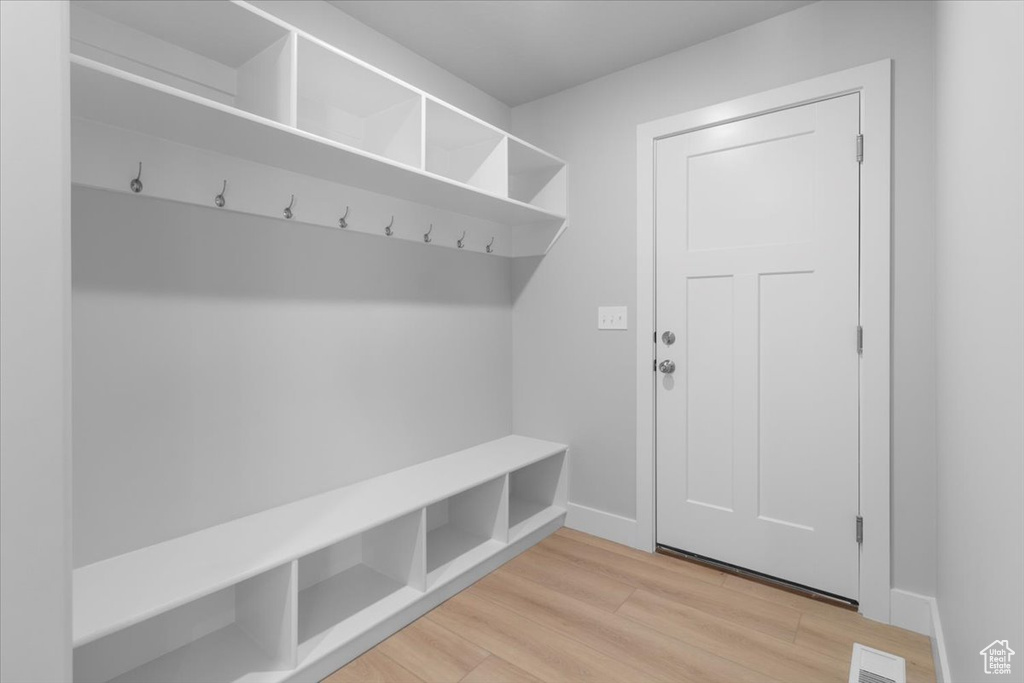 Mudroom featuring light wood-style flooring and baseboards