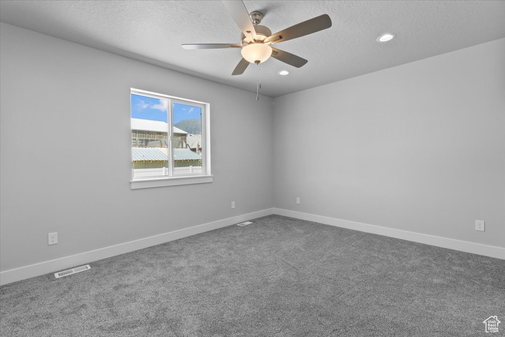 Spare room featuring ceiling fan, a textured ceiling, dark colored carpet, and recessed lighting