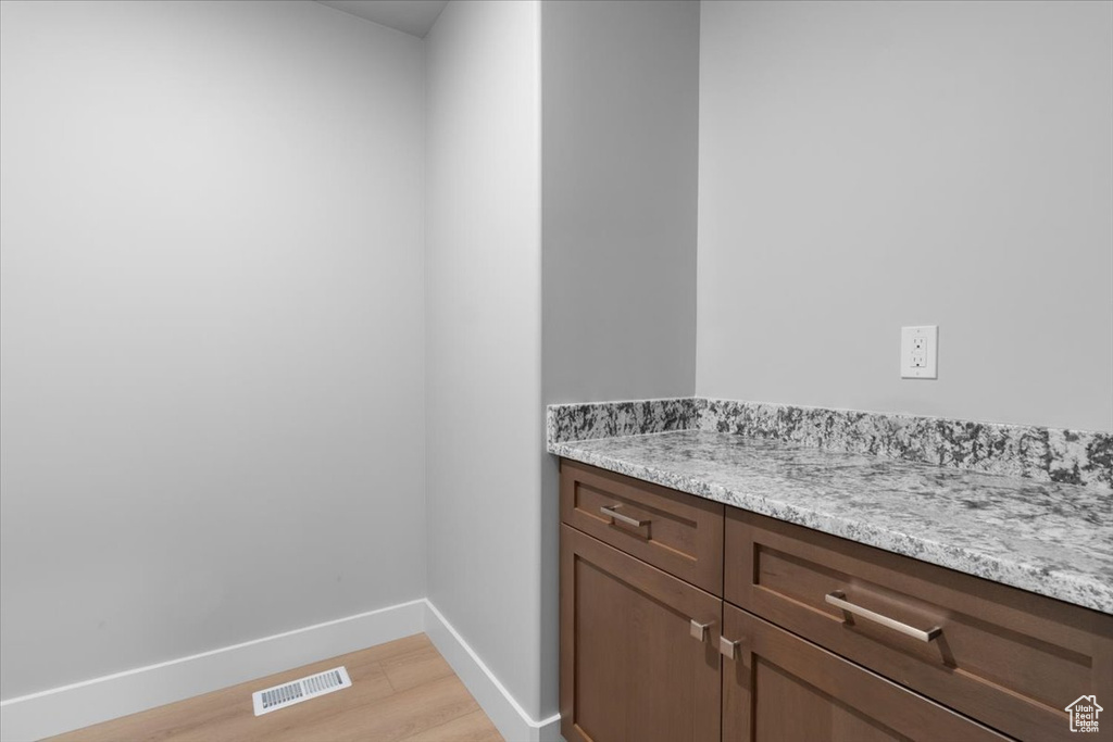 Laundry area with baseboards and light wood-style floors