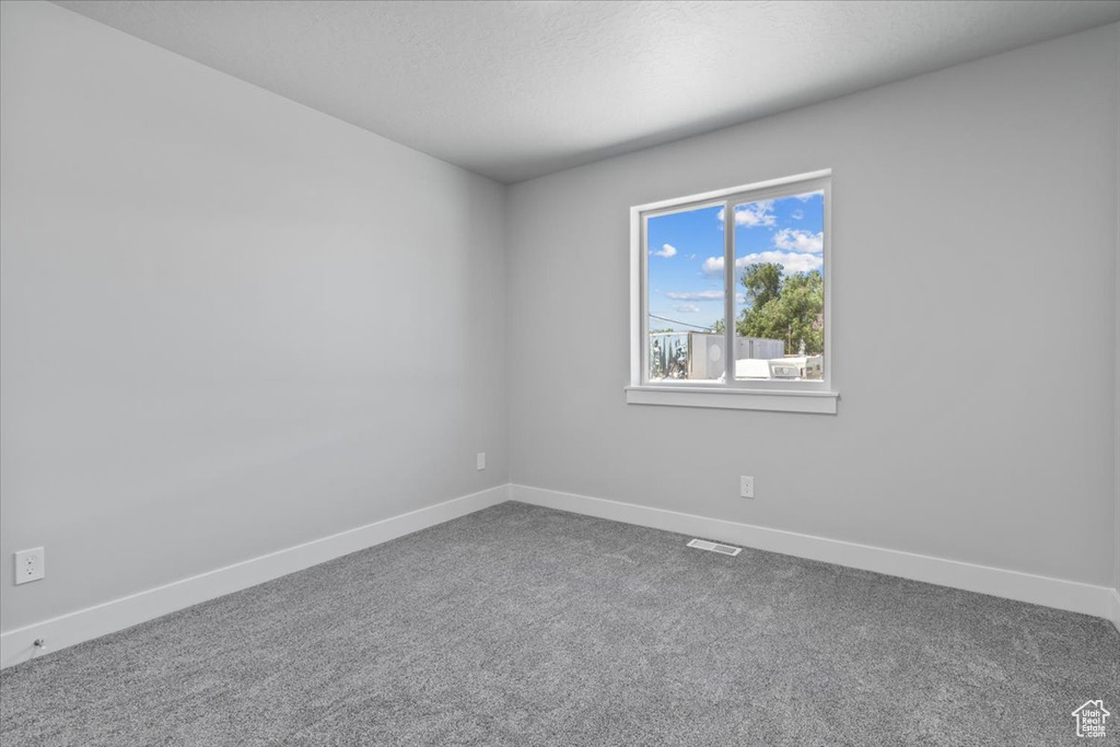 Carpeted empty room with baseboards