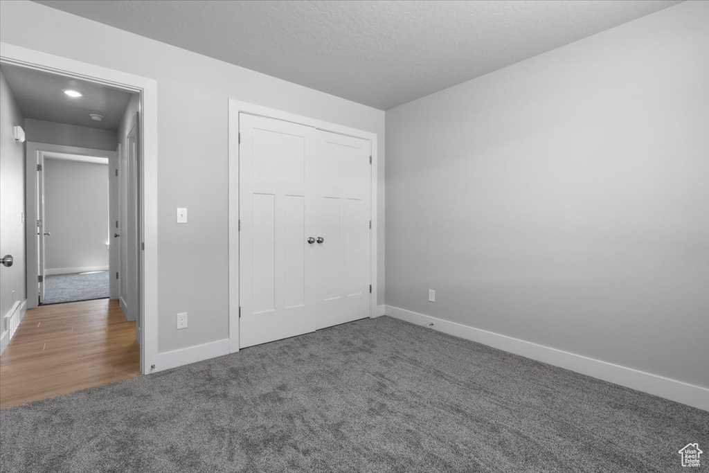 Unfurnished bedroom with carpet flooring and baseboards