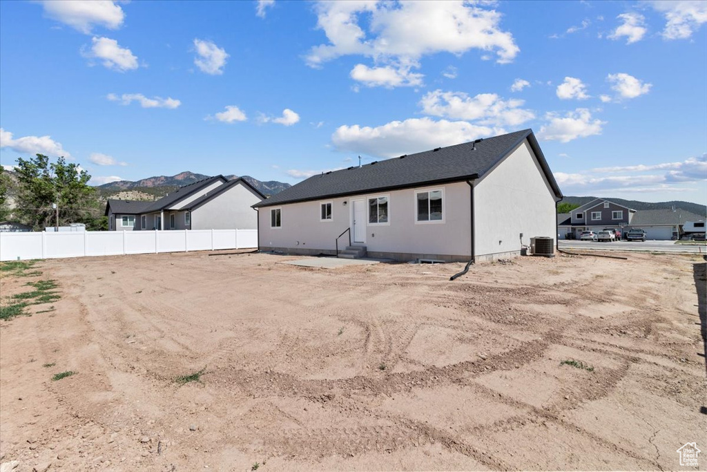 Back of property with entry steps and a mountain view